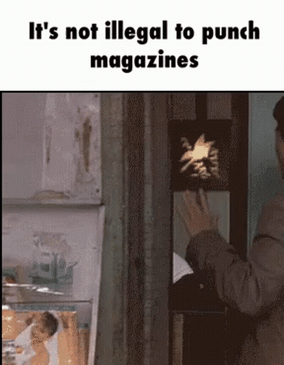 Man In Suit Standing In Front Of Sign It's Not Illegal To Punch Magazines GIF