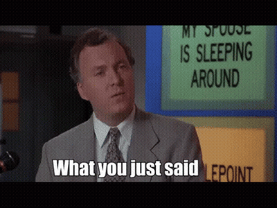 Man In Suit Standing In Front Of Sign Saying My Spouse Is Sleeping Around GIF