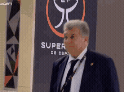 Man In Suit Standing In Front Of Super De Esp Sign GIF