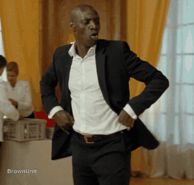 Man In Suit Standing In Front Of Table Saying Brownunit GIF