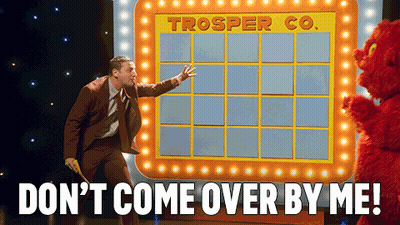 Man In Suit Standing In Front Of Trooper Co. Board GIF