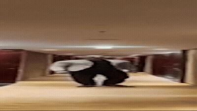 Man In Suit Standing In Hallway With Legs Crossed GIF