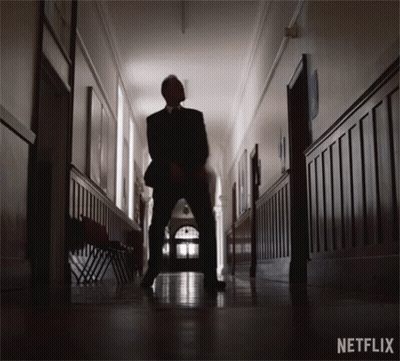 Man In Suit Standing In Hallway With Netflix GIF