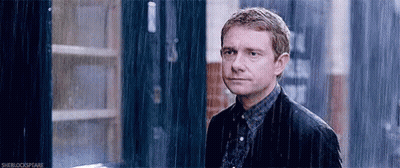 Man In Suit Standing In Rain Looking At Camera GIF