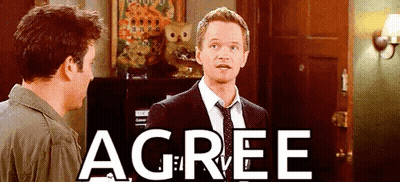 Man In Suit Standing Next To Another Man With Agree On Wall GIF