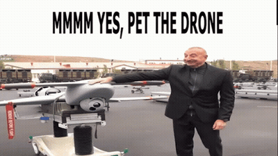 Man In Suit Standing Next To Drone Saying Mmmm Yes Pet The Drone GIF