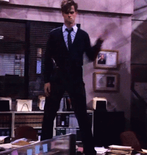 Man In Suit Standing On Desk GIF