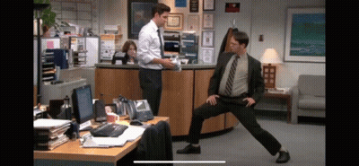 Man In Suit Standing On One Leg In Office GIF