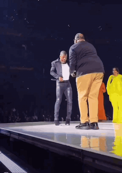 Man In Suit Standing On Stage With Another Man GIF
