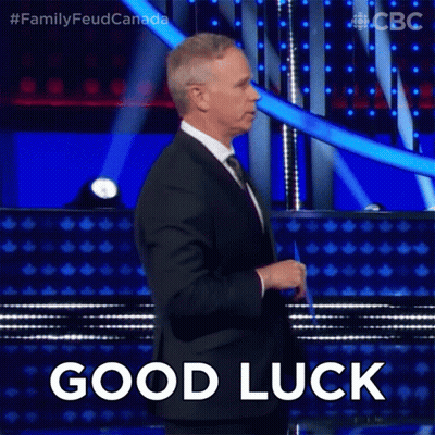 Man In Suit Standing On Stage With Good Luck GIF