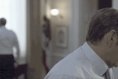 Man In Suit Standing With Woman In Background GIF