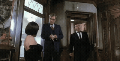 Man In Suit Stands In Front Of Woman In Black Dress GIF