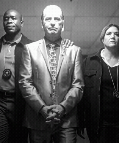 Man In Suit Surrounded By Police And Woman With Star Necklace GIF