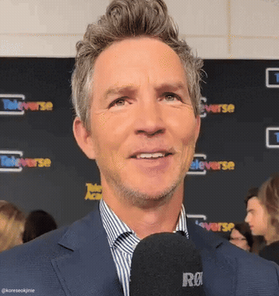 Man In Suit Talking Into Microphone Smiling GIF