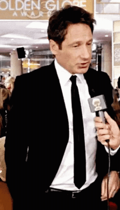 Man In Suit Talking Into Microphone To Crowd GIF