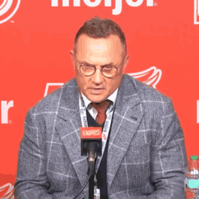 Man In Suit Talking Into Microphone With Glasses GIF