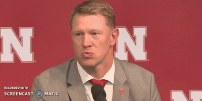 Man In Suit Talking Into Microphone With Letter N GIF