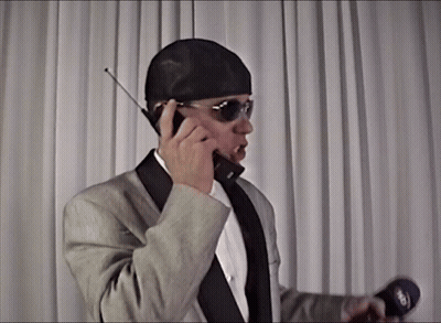 Man In Suit Talking On Cell Phone Holding Microphone Saying Sky GIF