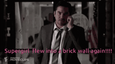 Man In Suit Talking On Cell Phone Says Supergirl Flew Into Brick Wall Again GIF