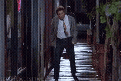Man In Suit Talking On Cell Phone Walking Wet Sidewalk GIF