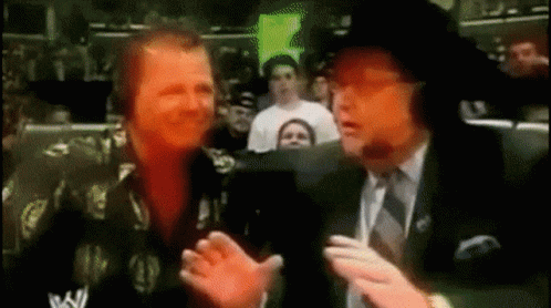 Man In Suit Talking To Another Man In Crowd GIF