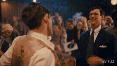 Man In Suit Talking To Another Man In Crowded Room GIF