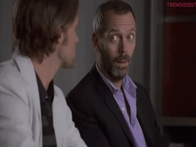 Man In Suit Talking To Man In White Jacket GIF
