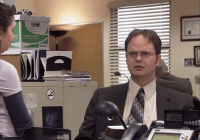 Man In Suit Talking To Woman By Storage Boxes GIF