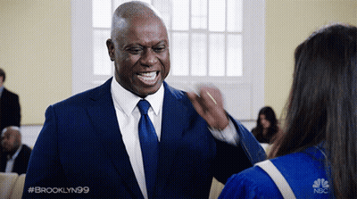 Man In Suit Talking To Woman In Graduation Gown GIF