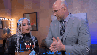 Man In Suit Talking To Woman In Wig Saying Let Me Know What Mami Says GIF
