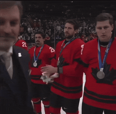 Man In Suit Talks To Hockey Players In Red A Jerseys GIF
