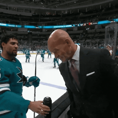 Man In Suit Talks To Man In Sharks Jersey GIF