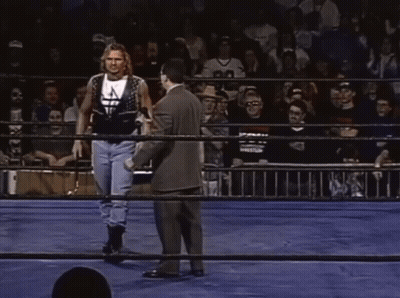 Man In Suit Talks To Wrestler In Ring With Crowd GIF