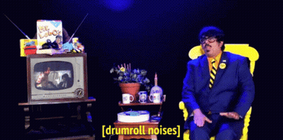 Man In Suit Tie Watching TV Drumroll Noises GIF