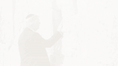 Man In Suit Touching Stone Wall With American Flag GIF
