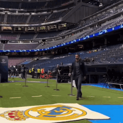 Man In Suit Walking Across Soccer Field GIF