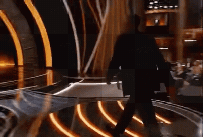 Man In Suit Walking Across Stage At Awards Show GIF