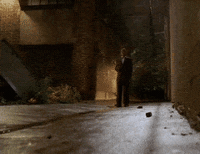 Man In Suit Walking Down Dark Alley GIF