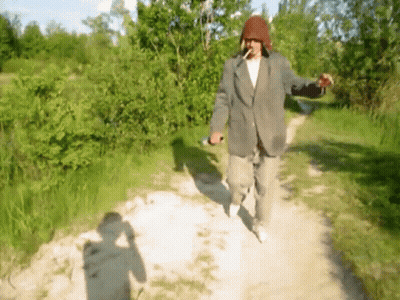 Man In Suit Walking Down Dirt Path Smoking Cigarette GIF