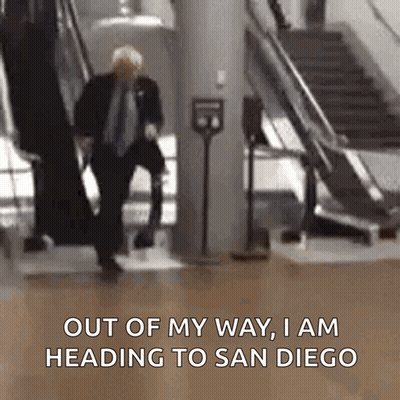 Man In Suit Walking Down Escalator Out Of My Way I Am Heading To San Diego GIF