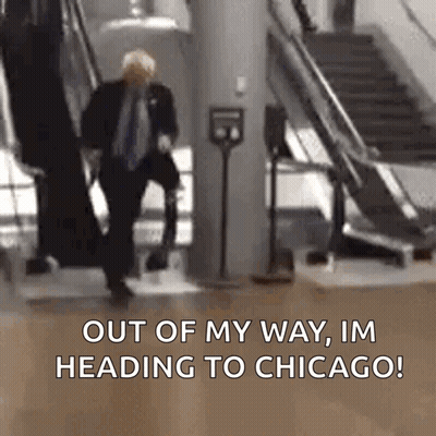 Man In Suit Walking Down Escalator Says Out Of My Way I'm Heading To Chicago GIF