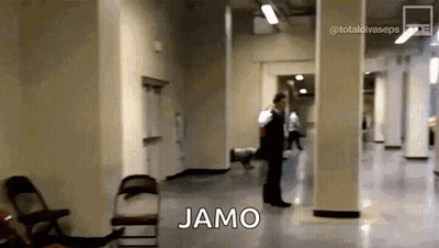 Man In Suit Walking Down Hallway With Jamo On Floor GIF