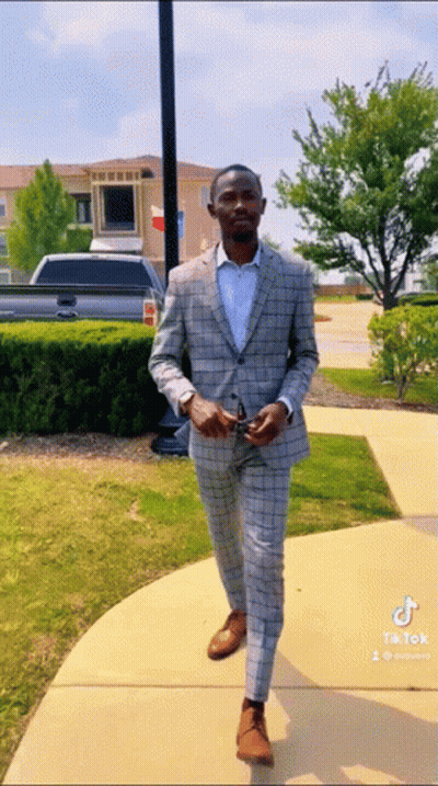 Man In Suit Walking Down Sidewalk With TikTok Watermark GIF