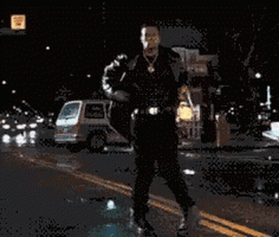 Man In Suit Walking Down Street At Night GIF