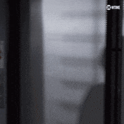 Man In Suit Walking On Wet Street At Night GIF