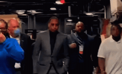 Man in Suit Walking Through Masked Crowd