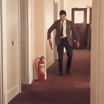 Man In Suit Walking With Fire Extinguisher GIF