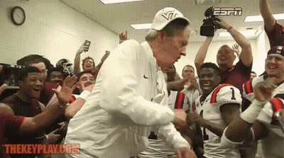 Man In Suit Watching Football With Frank Beamer Above GIF