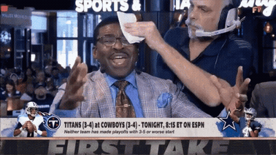 Man In Suit Wiping Face With Napkin While Headset Man Looks On GIF