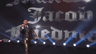 Man In Suit With AEW Sign GIF